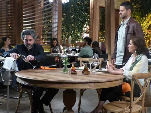 Comendador senta na mesa do casal e deixa inimigo irritado (Foto: Paula Paiva/Gshow)