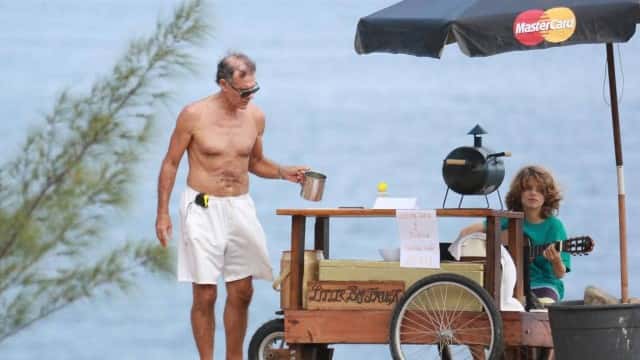 Mário Gomes vendendo hambúrguer na praia. (Foto: Cristiana Silva)