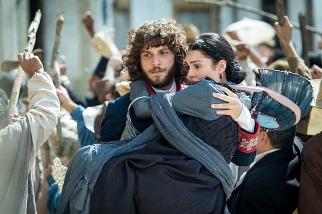 Joaquim (Chay Suede) tira Anna (Isabelle Drummond) do meio da multidão em 'Novo Mundo' (Foto: Globo/Raquel Cunha)