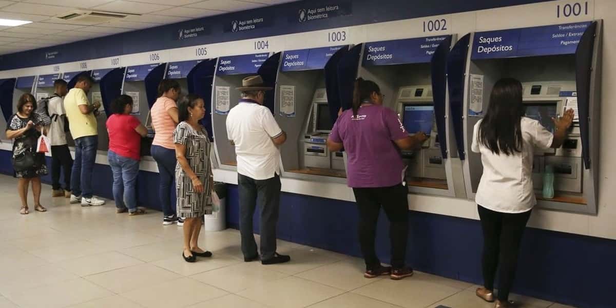 Pessoas utilizando o caixa eletrônico (Foto: Reprodução / Internet)