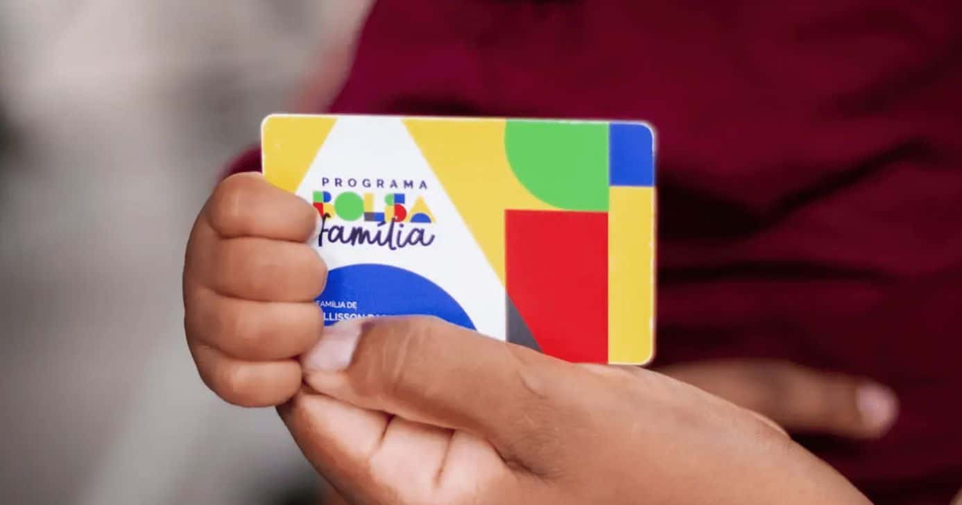 Pessoas segurando o cartão do Bolsa Família (Foto: Site oficial do PT)
