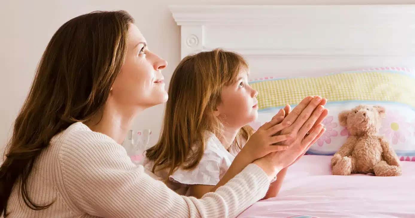 Mãe e filha fazendo oração (Foto: Canva)