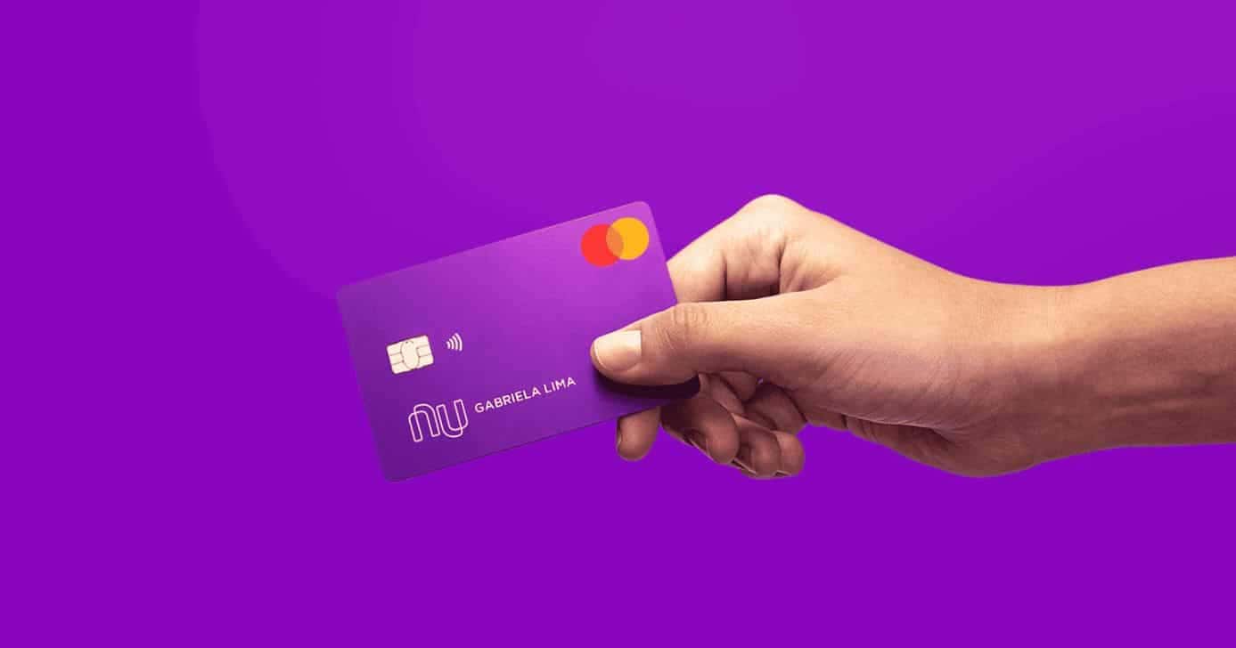 Mulher segurando cartão do Nubank (Foto: Divulgação)