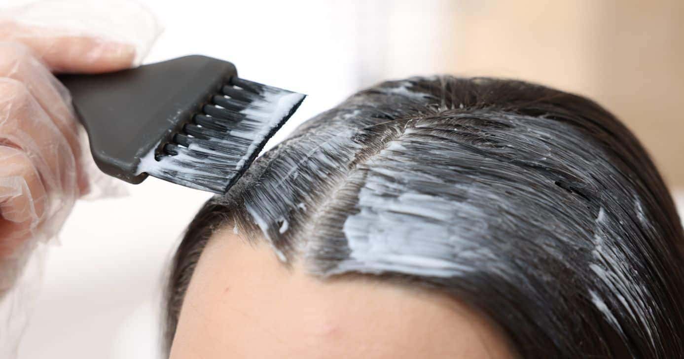 Mulher pintando o cabelo (Foto: Canva)