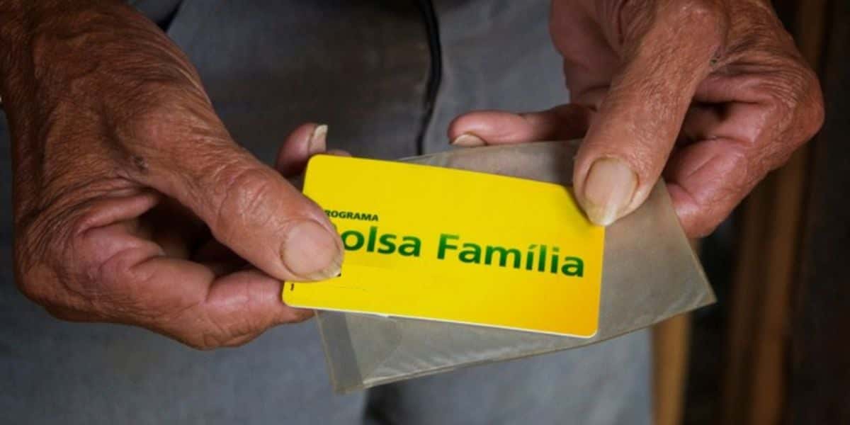 Idoso segurando cartão do Bolsa família - Foto Reprodução Internet