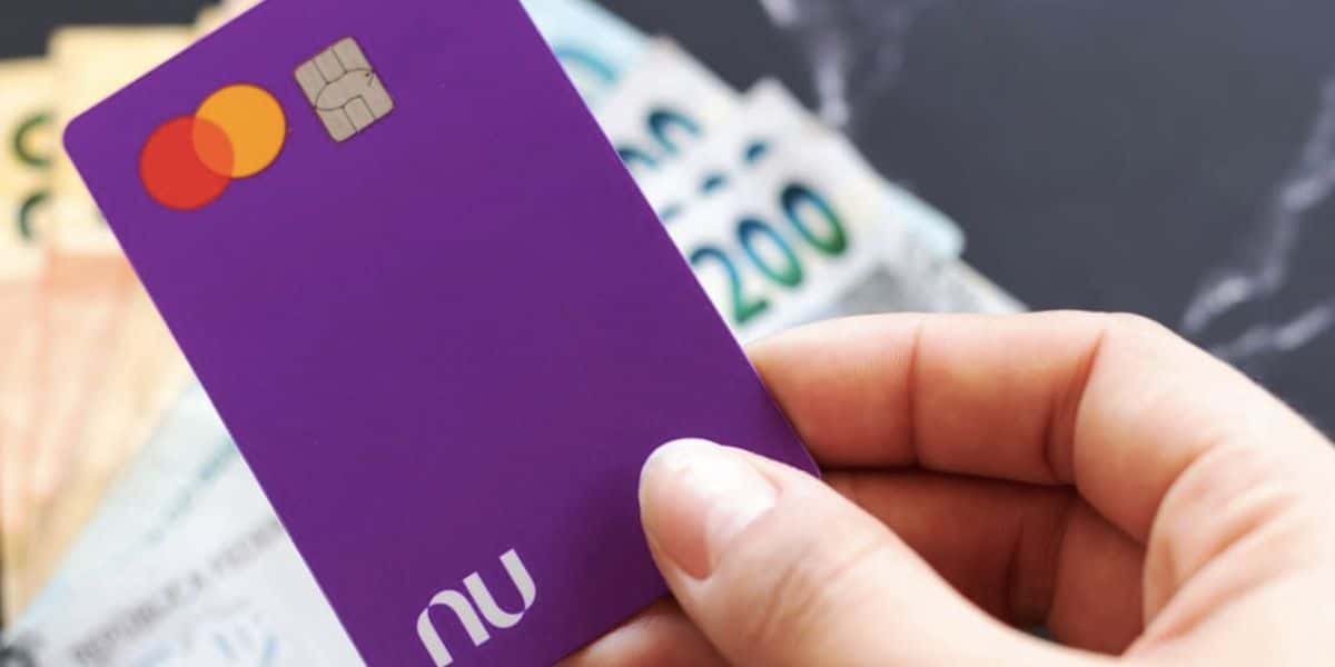 Pessoa segurando cartão do Nubank e notas de dinheiro (Foto: Reprodução / Internet)