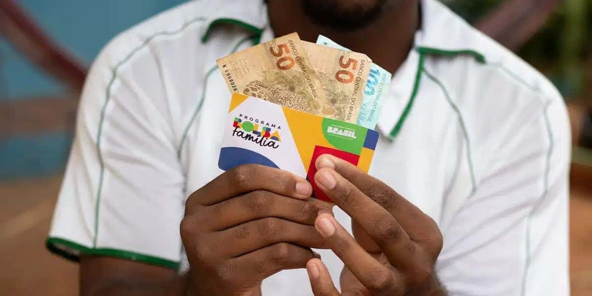 Homem segurando cartão do Bolsa Família e dinheiro (Foto: Reprodução, Pronatec)