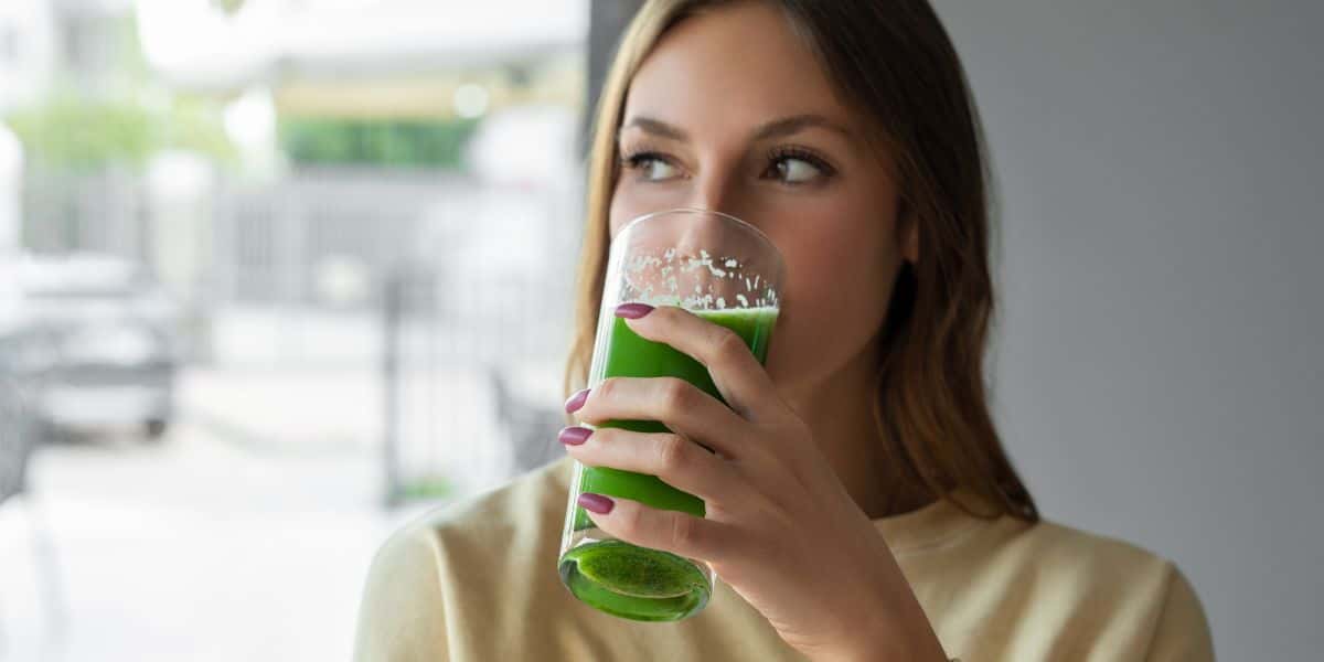 Jovem bebendo suco (Foto: Canva)