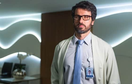 Homem de pé sério caracterizado como médico, ator no bastidor da novela O Outro Lado do Paraíso