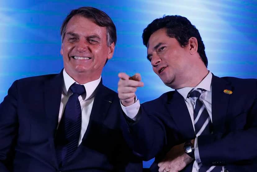 Sergio Moro e Jair Bolsonaro - filho do presidente, Flávio Bolsonaro, é acusado de chefiar organização criminosa; primeira-dama, Michelle Bolsonaro, recebeu cheque suspeito de R$ 20 mil (Foto: Reprodução) Sergio Moro e Jair Bolsonaro - filho do presidente, Flávio Bolsonaro, é acusado de chefiar organização criminosa; primeira-dama, Michelle Bolsonaro, recebeu cheque suspeito de R$ 20 mil (Foto: Reprodução)