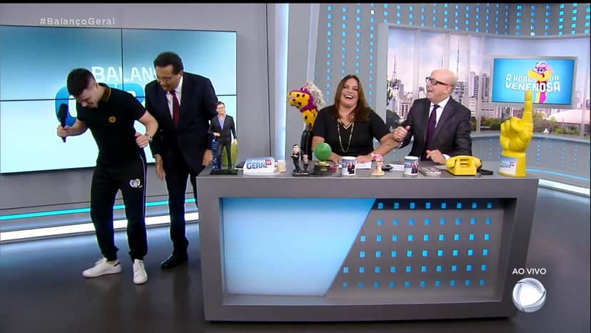 Luiz Bacci "invade a Hora da Venenosa e faz dancinha para Geraldo Luiz e Fabíola Reipert (Imagem: Reprodução) Luiz Bacci "invade a Hora da Venenosa e faz dancinha para Geraldo Luiz e Fabíola Reipert (Imagem: Reprodução)