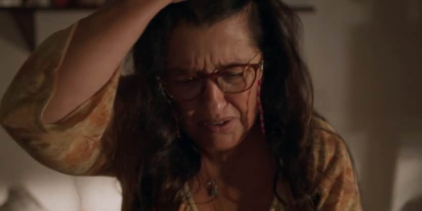 Lurdes segura cabelos longos e escuros com as mãos e tem expressão de desespero em Amor de Mãe Lurdes segura cabelos longos e escuros com as mãos e tem expressão de desespero em Amor de Mãe