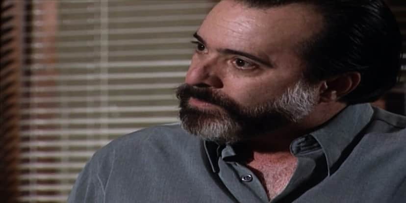 Miguel, homem que usa camisa social azul, é branco e tem barba da cor preta e branca está em cena da novela Laços de Família com expressão de raiva Miguel, homem que usa camisa social azul, é branco e tem barba da cor preta e branca está em cena da novela Laços de Família com expressão de raiva