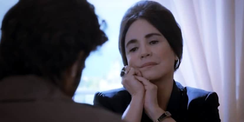 Maria Joaquina, personagem de Império, é uma mulher de cabelo preto, pela branca, que observa homem com as mãos dadas frente embaixo do queixo Maria Joaquina, personagem de Império, é uma mulher de cabelo preto, pela branca, que observa homem com as mãos dadas frente embaixo do queixo