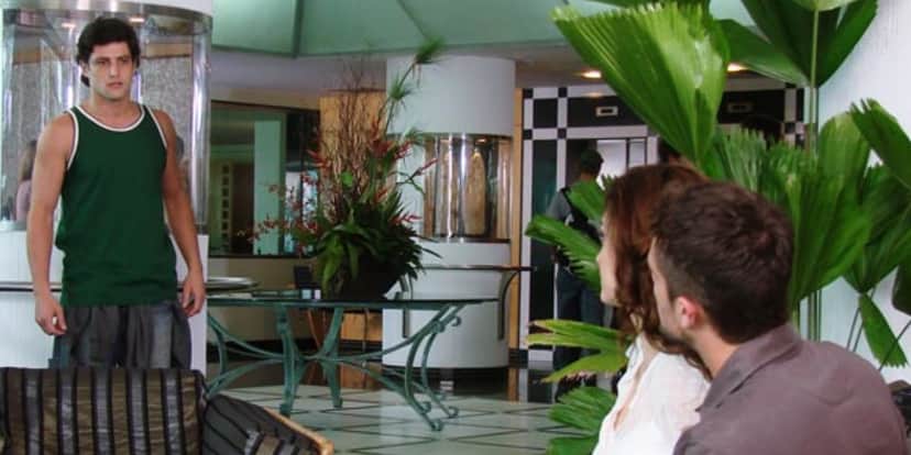 em recepção de hotel na novela ti-ti-ti armandinho vestido de verde flagra desirée e jorgito sentados em sofá em recepção de hotel na novela ti-ti-ti armandinho vestido de verde flagra desirée e jorgito sentados em sofá