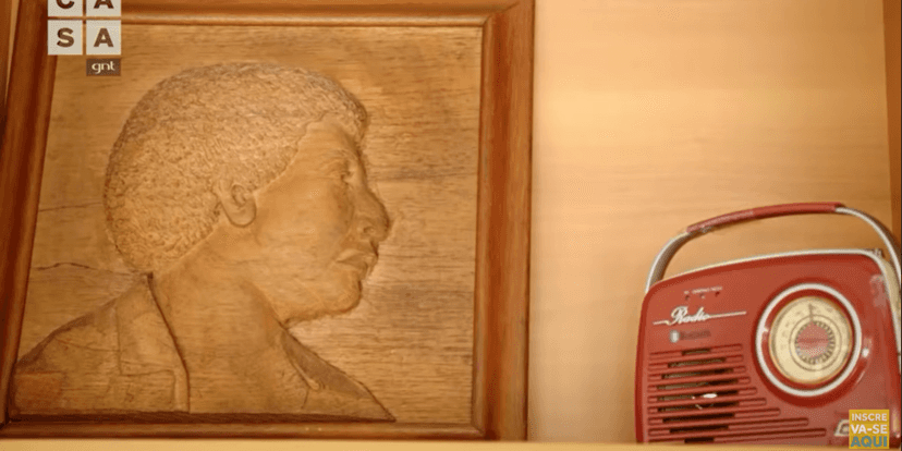 Quadro de madeira retratando o pai de Diogo Nogueira ao lado de um rádio antigo (Foto Reprodução/Youtube) Quadro de madeira retratando o pai de Diogo Nogueira ao lado de um rádio antigo (Foto Reprodução/Youtube)