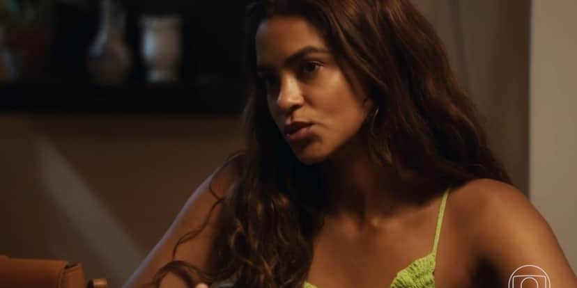 Brisa é personagem da novela Travessia, uma mulher preta com cabelos longos e castanhos que usa uma regata da cor verde Brisa é personagem da novela Travessia, uma mulher preta com cabelos longos e castanhos que usa uma regata da cor verde