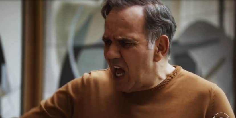 Guerra usando blusa de frio laranja em cena de Travessia Guerra usando blusa de frio laranja em cena de Travessia