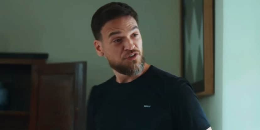 Theo, homem branco que usa camiseta preta e tem barba e cabelos lisos castanhos está em cena da novela Vai na Fé Theo, homem branco que usa camiseta preta e tem barba e cabelos lisos castanhos está em cena da novela Vai na Fé
