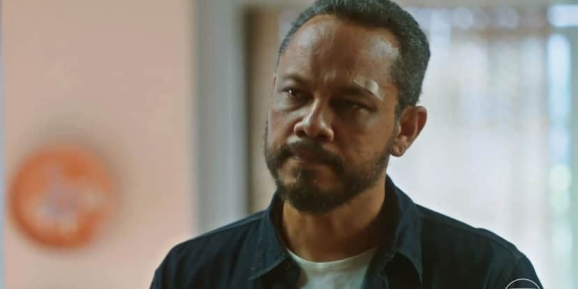 Carlão em cena da novela Vai na Fé usando camisa manga curta azul e camisa branca Carlão em cena da novela Vai na Fé usando camisa manga curta azul e camisa branca