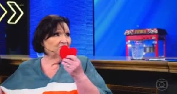 Dona Déa arrancou corações de dentro da blusa e entregou para Luciano Huck (Foto: Globoplay) Dona Déa arrancou corações de dentro da blusa e entregou para Luciano Huck (Foto: Globoplay)