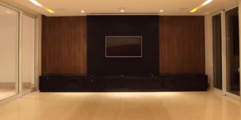 Sala de estar enorme e televisão no centro do cômodo (Reprodução: Youtube) Sala de estar enorme e televisão no centro do cômodo (Reprodução: Youtube)