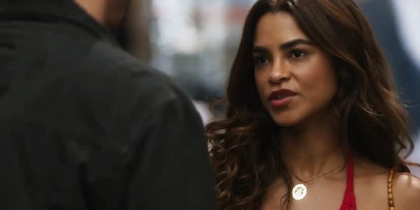 Brisa em cena da novela Travessia usando colar de prata e blusa fina vermelha além de um cabelo longo e castanho Brisa em cena da novela Travessia usando colar de prata e blusa fina vermelha além de um cabelo longo e castanho