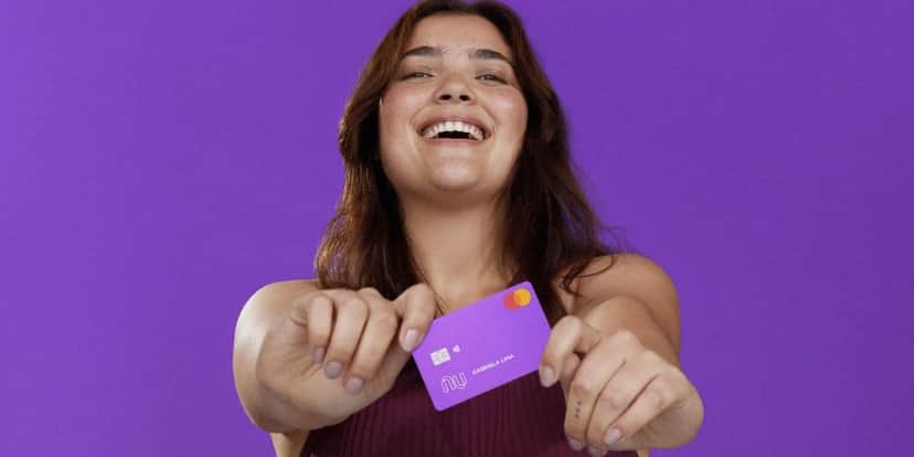 Pessoa feliz segurando cartão do Nubank (Foto: Reprodução / site do banco) Pessoa feliz segurando cartão do Nubank (Foto: Reprodução / site do banco)