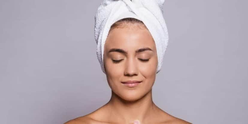 Mulher com toalha na cabeça (Foto: Canva) Mulher com toalha na cabeça (Foto: Canva)