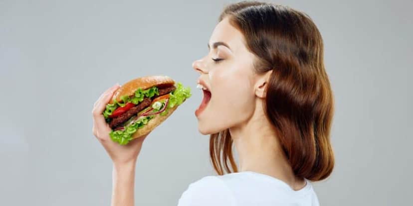 Mulher comendo lanche (Foto: Canva) Mulher comendo lanche (Foto: Canva)