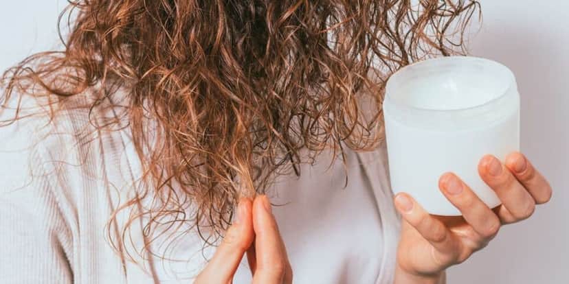 Jovem hidratando o cabelo (Foto: Canva) Jovem hidratando o cabelo (Foto: Canva)