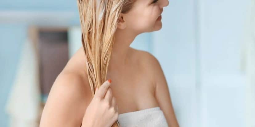 Mulher hidratando o cabelo loiro (Foto: Canva) Mulher hidratando o cabelo loiro (Foto: Canva)