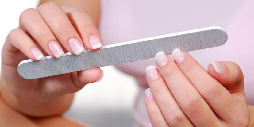 Mulher lixando unhas (Foto: Canva) Mulher lixando unhas (Foto: Canva)