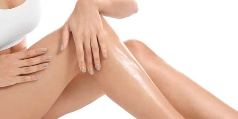 Mulher passando creme na perna (Foto: Canva) Mulher passando creme na perna (Foto: Canva)