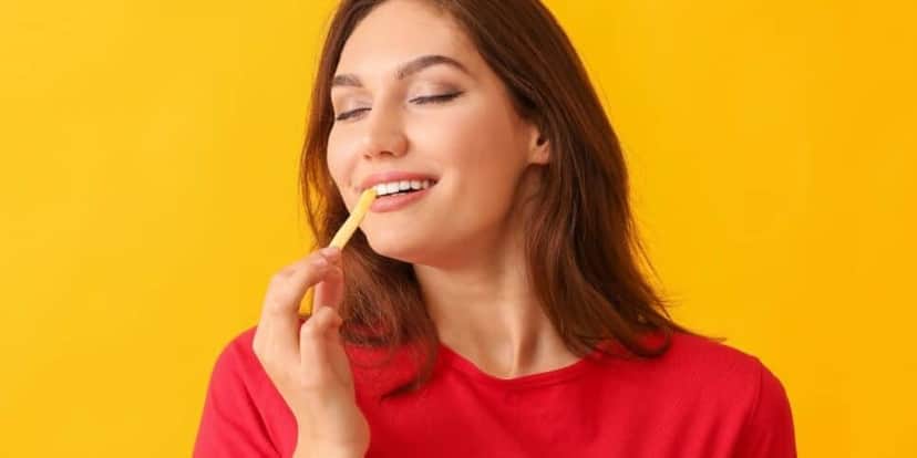 Mulher comendo batata frita (Foto: Canva) Mulher comendo batata frita (Foto: Canva)
