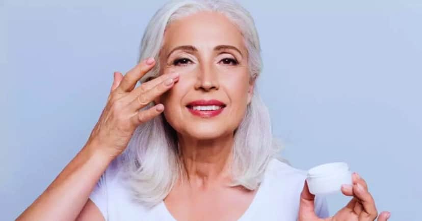 Mulher 60+ passando creme rejuvenescedor no rosto (Foto Reprodução/Freepik) Mulher 60+ passando creme rejuvenescedor no rosto (Foto Reprodução/Freepik)