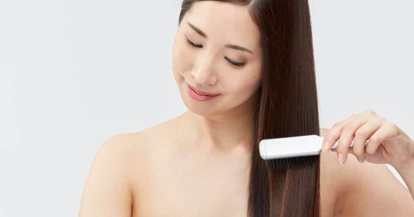 Mulher penteando o cabelo (Foto: Canva) 