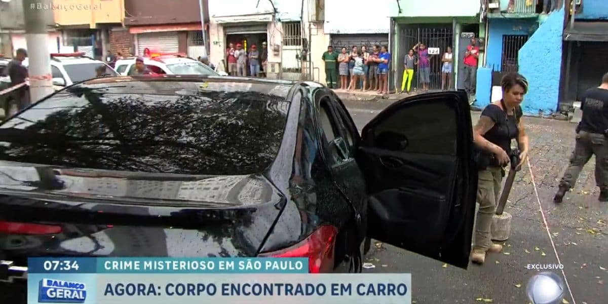 O corpo ainda estava dentro do carro quando a reportagem chegou (Reprodução: Record) O corpo ainda estava dentro do carro quando a reportagem chegou (Reprodução: Record)