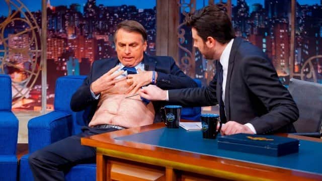 Bolsonaro quebra o protocolo e tira a camisa no The Noite com Danilo Gentili (Foto: Gabriel Cardoso/SBT) Bolsonaro quebra o protocolo e tira a camisa no The Noite com Danilo Gentili (Foto: Gabriel Cardoso/SBT)