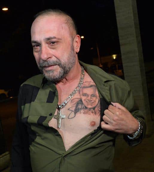 Amigo de Gugu, o diretor Goiabinha, exibe tatuagem do apresentador na missa do sétimo dia (Foto: Reprodução) Amigo de Gugu, o diretor Goiabinha, exibe tatuagem do apresentador na missa do sétimo dia (Foto: Reprodução)