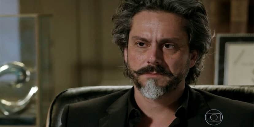 José Alfredo, homem mais velho com barba e cabelos grisalhos e preto com terno preto em cena da novela Império José Alfredo, homem mais velho com barba e cabelos grisalhos e preto com terno preto em cena da novela Império