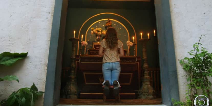 Luna está ajoelhada em altar rezando em cena de Salve-se Quem Puder Luna está ajoelhada em altar rezando em cena de Salve-se Quem Puder