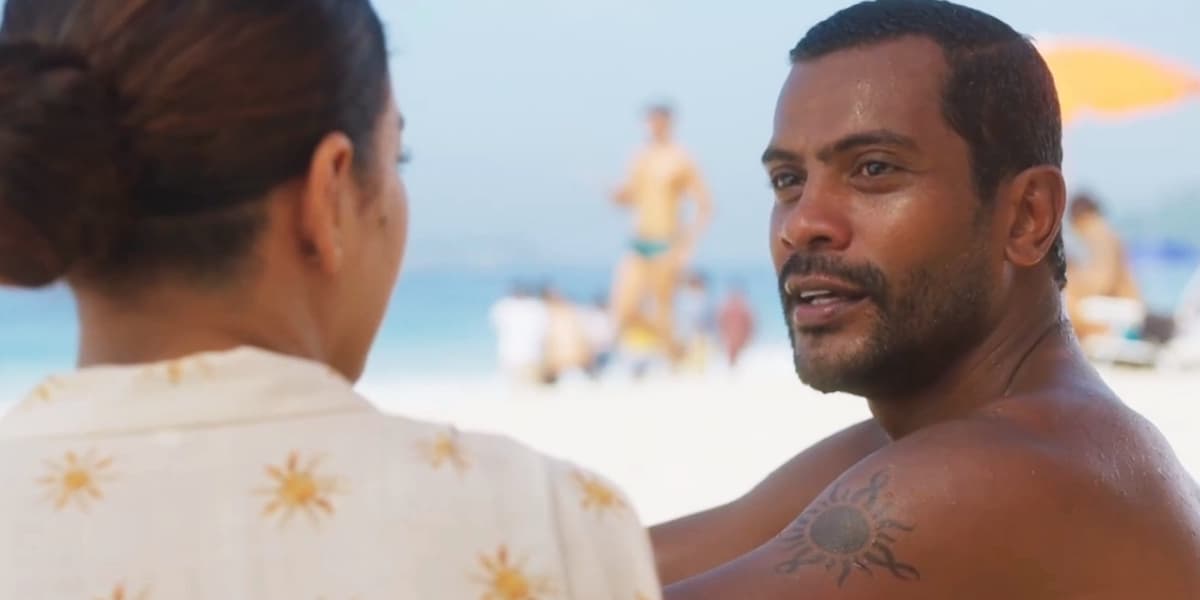 Ben e Jenifer conversam sentados na areia da praia Ben e Jenifer conversam sentados na areia da praia