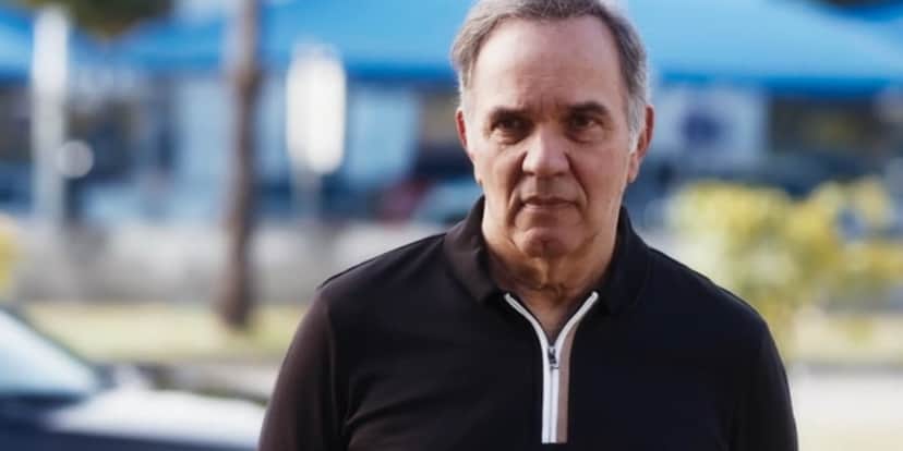 Guerra da novela Travessia está ao ar livre, usando um camisa preta com detalhe do zíper branco Guerra da novela Travessia está ao ar livre, usando um camisa preta com detalhe do zíper branco
