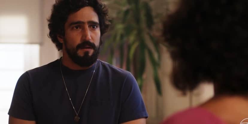 Tertulinho usando camisa azul de manga curta, barba e cabelo preto em cena da novela Mar do Sertão Tertulinho usando camisa azul de manga curta, barba e cabelo preto em cena da novela Mar do Sertão