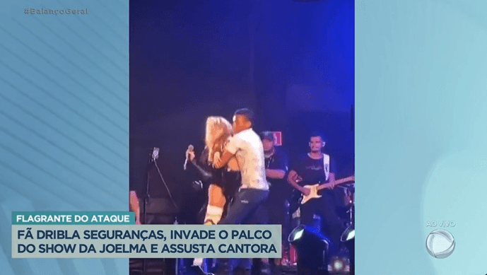 Joelma sendo agarrada por fã no palco (Foto Reprodução/PlayPlus) Joelma sendo agarrada por fã no palco (Foto Reprodução/PlayPlus)