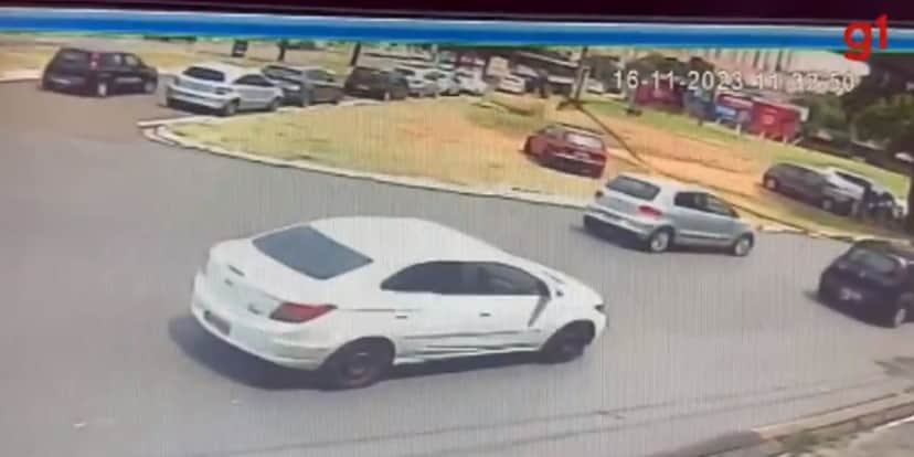 No canto direito inferior, as pessoas se protegem atrás do carro, no momento dos disparos (Reprodução: Internet) No canto direito inferior, as pessoas se protegem atrás do carro, no momento dos disparos (Reprodução: Internet)