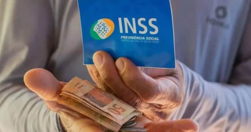 Idoso segurando notas de cem reais e cartão do INSS (Foto: Reprodução / Internet) Idoso segurando notas de cem reais e cartão do INSS (Foto: Reprodução / Internet)