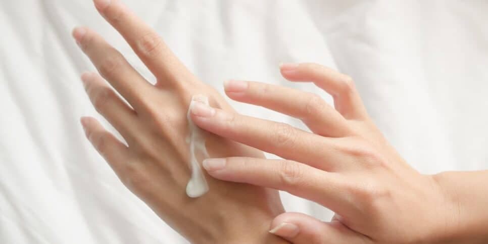 Mulher passando creme nas mãos (Foto: Canva) Mulher passando creme nas mãos (Foto: Canva)