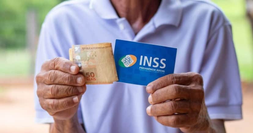 Homem segurando notas de cinquenta reais e cartão do INSS (Foto: Reprodução / Jeane De Oliveira) Homem segurando notas de cinquenta reais e cartão do INSS (Foto: Reprodução / Jeane De Oliveira)